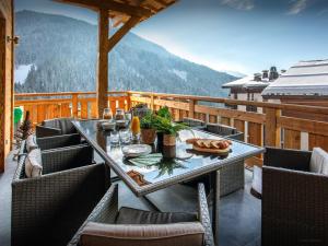 a table and chairs on a balcony with a view at Chalet Alyssum - OVO Network in Le Grand-Bornand