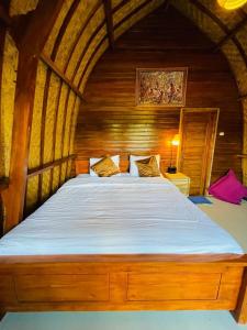 Cette chambre en bois comprend un grand lit. dans l'établissement Dimas Villa, à Kintamani