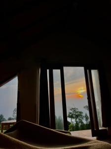 a view of a sunset from a bedroom window at Bali Sunrise Cabin in Bangli