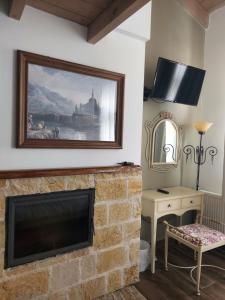 a living room with a fireplace and a painting on the wall at VIRSA BOUTIQUE ROOMS in Ioannina