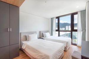 2 camas en una habitación con ventana grande en Centum Convention Hotel In Centum, en Busan