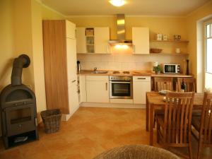 a kitchen with a stove and a wooden table with a tableablish at Exkl App Strandmuschel, Kamin, 250 m zum Strand in Börgerende-Rethwisch