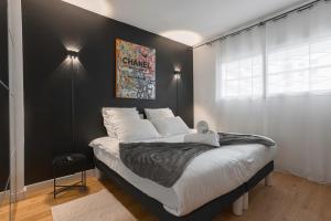 a bedroom with a large bed with a black wall at L'élégant Maubourg - Next Hotel Martinez -Terrasse in Cannes