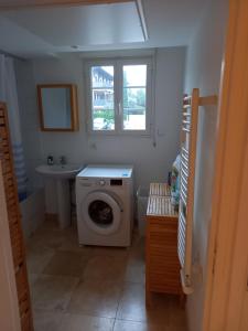 een badkamer met een wasmachine en een wastafel bij Appartement premium T3 résidence piscine in La Croix-Valmer