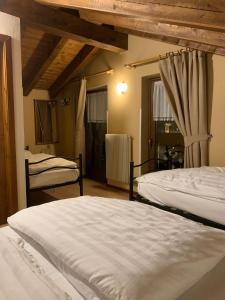 ピンツォーロにあるGarnì Bonsaiのベッドルーム1室(ベッド2台、窓付)
