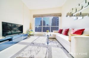 a living room with a couch and a tv at Contemporary One Bedroom with Full Marina View in Dubai