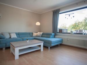 ヴィンターベルクにあるLarge Apartment near Ski Area in Winterberg Germanyのリビングルーム(青いソファ、テーブル付)