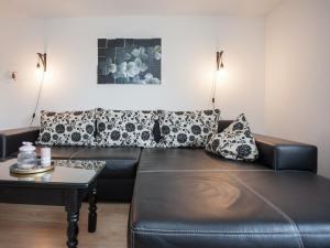 a black leather couch in a living room with a table at Modern apartment in Neuastenberg directly on a ski area in Winterberg