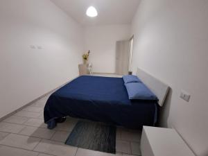 a bedroom with a blue bed in a white room at Casa Lombardo in Crotone