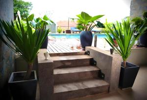 a set of stairs with potted plants and a pool at WATBO BRIDGE Residence in Siem Reap