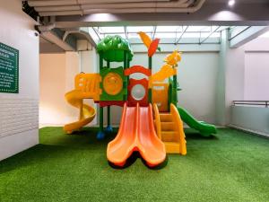 uma sala de jogos com um parque infantil com um escorrega em Homes at Bay Area Suites by SMS Hospitality em Manila