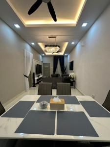 un soggiorno con tavolo e ventilatore a soffitto di MK Homestay Perlis ad Arau