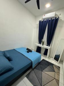 a bedroom with a blue bed and blue curtains at MK Homestay Perlis in Arau