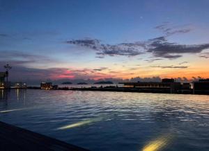 a pool of water with a sunset in the background at Cantara Escape Lily in Kota Kinabalu