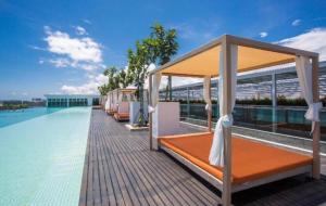 a bed on the roof of a building next to the water at Cantara Escape Lily in Kota Kinabalu