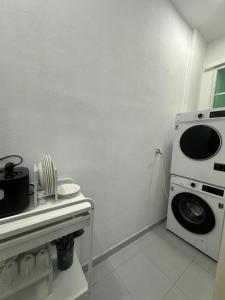 a kitchen with a washing machine and a microwave at MK Homestay Perlis in Arau