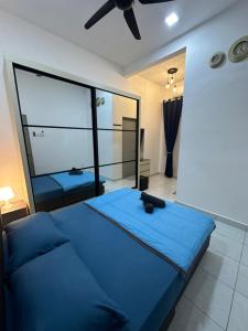 a bedroom with a blue bed and a large mirror at MK Homestay Perlis in Arau