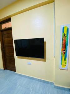 einen Flachbild-TV an der Wand in einem Zimmer in der Unterkunft Qarib Rock City in Mwanza
