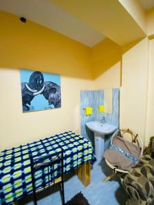 ein Schlafzimmer mit einem Bett und einem Waschbecken in einem Zimmer in der Unterkunft Qarib Rock City in Mwanza