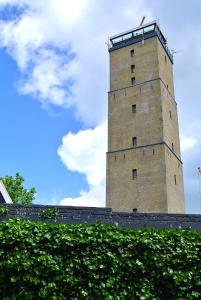 
a tall tower with a clock on it's side at Hotel B&B Altijd Wad in West-Terschelling
