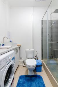 y baño con aseo y lavadora. en 2 комнатная квартира в сердце города - цокольный этаж en Almaty