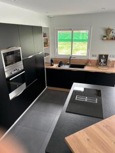 a kitchen with a black refrigerator and a counter at Comme à la maison in Neuvy-Sautour +8 photos