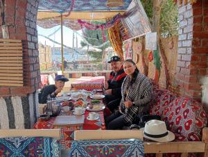 eine Gruppe von Menschen, die an einem Tisch mit Essen sitzen in der Unterkunft White Villa in Luxor