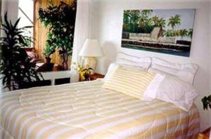 a bedroom with a bed with a painting on the wall at Hale-Hoola B & B in Captain Cook