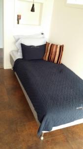 Bett mit blauer Decke in einem Zimmer in der Unterkunft Vinbergs Stugby in Vinberg