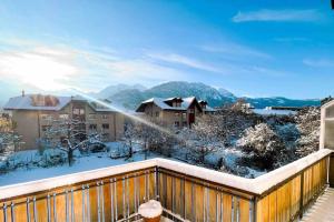 a balcony with snow covered trees and buildings at -The Urbanist- Mountainview Parking Garden 3BD in Unterseen