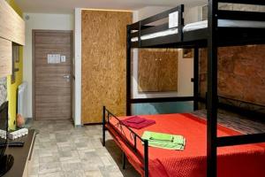 1 dormitorio con litera y colcha roja en Ca' di Ruchitt- Happy Rentals en Cuasso Al Monte