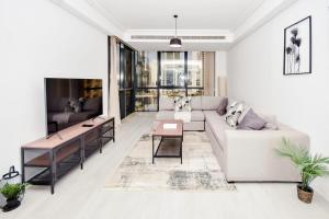 uma sala de estar com um sofá e uma mesa em LUXFolio Retreats Beautiful JLT 1BR Apartment em Dubai