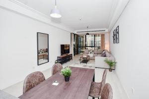 uma sala de estar com uma mesa de madeira e cadeiras em LUXFolio Retreats Beautiful JLT 1BR Apartment em Dubai