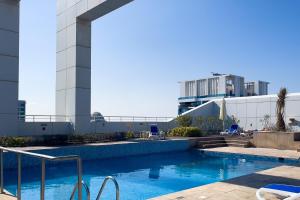 uma piscina em frente a um edifício em LUXFolio Retreats Beautiful JLT 1BR Apartment em Dubai