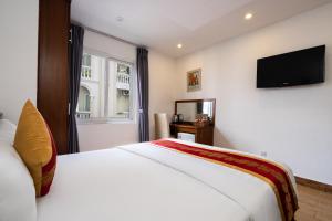 ホーチミン・シティにあるKing Hotel Saigon Airportのベッドとテレビが備わるホテルルームです。