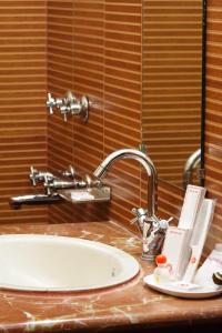 a bathroom counter with a sink and a mirror at Sun Hotel-Haridwar in Haridwār