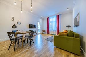 a living room with a table and a green couch at Apartamenty House Managers - Bursztynowa Zatoka in Sopot