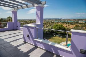 a purple house with a balcony with a view at Villa Dalousa Retreat - Porto Heli in Porto Heli
