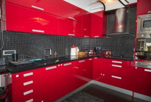 a red kitchen with red cabinets and black tiles at Villa Dalousa Retreat - Porto Heli in Porto Heli