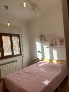 1 dormitorio con 1 cama con manta rosa en Casa vacanza Hydrangea con piscina e giardino, en Bagni di Lucca