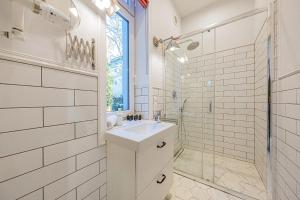 uma casa de banho branca com um lavatório e um chuveiro em Apartamenty House Managers - Bursztynowa Zatoka em Sopot