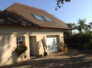 a white house with a door and a window at Jardin Des Énigmes in Boissay