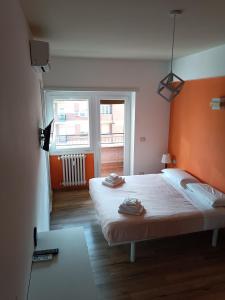 a bedroom with a bed with an orange headboard and a window at Il Coriandolo 2 in Rome