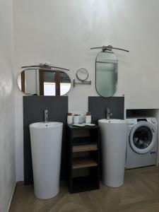 y baño con 2 lavabos y lavadora. en Casa vacanza Hydrangea con piscina e giardino, en Bagni di Lucca