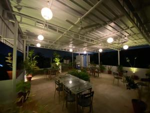 a patio with a table and chairs and potted plants at La Paradise Residency in Puducherry