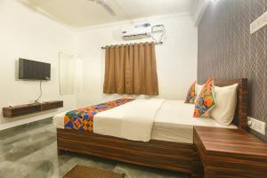 a bedroom with a bed and a television in it at FabExpress MA Homes in Morjim