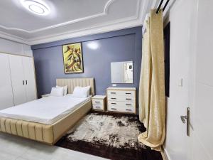 a bedroom with a bed and a blue wall at F3 Appart Les Ambassades - Point E - Dakar in Dakar