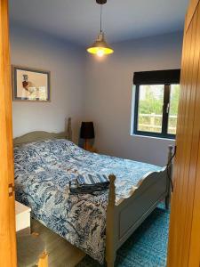a bedroom with a bed and a window at Bluebell Annexe in Little Grandsen