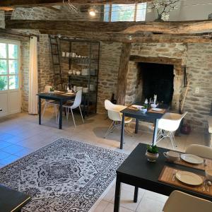 - un salon avec deux tables et une cheminée dans l'établissement Chambres d'hôtes Pech Blanc, à Calvignac