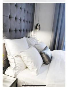 a white bed with white pillows on it at Belliss in Osijek